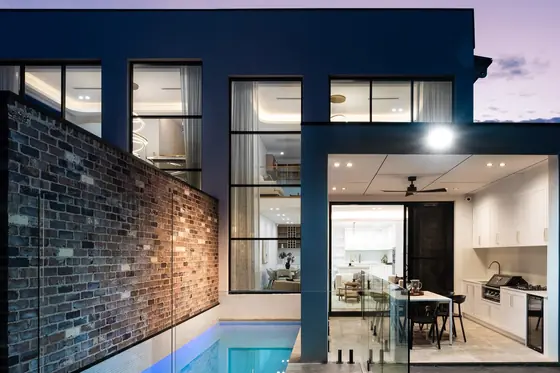 Rear of the home at dusk with pool and covered alfresco, a knockdown rebuild at 146 Wattle Road, Sutherland by St Anthony Building Group