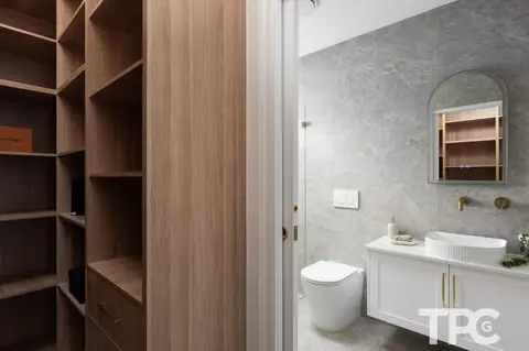 Walk-in wardrobe with timber shelving beside an ensuite – knockdown rebuild at 146 Wattle Road, Sutherland