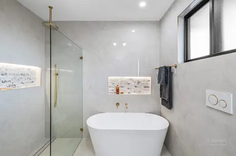 Bathroom with freestanding bath, frameless glass shower and lit niches – knockdown rebuild at 28 Aylesbury Crescent, Chipping Norton